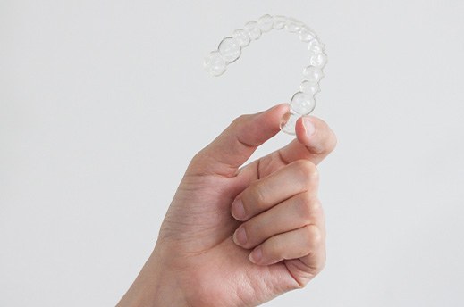 Closeup of patient holding clear aligner