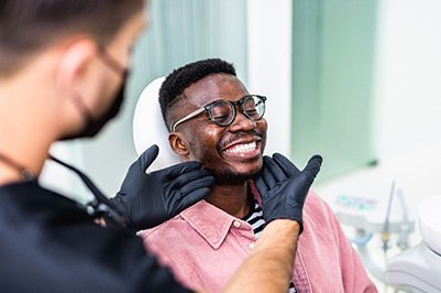 Dentist looking at patient's smile in treatment room