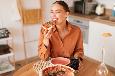 Woman smiling while enjoying homemade pizza