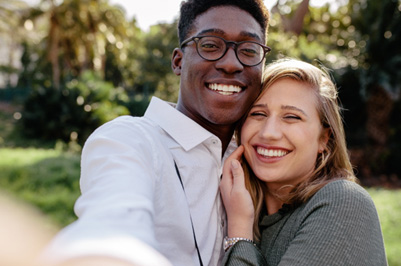 Couple smiling while hugging outside