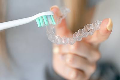 a Spark clear aligner next to a toothbrush