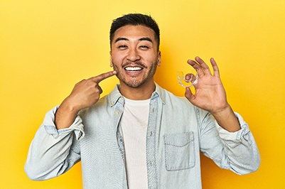 a patient holding his Spark clear aligner