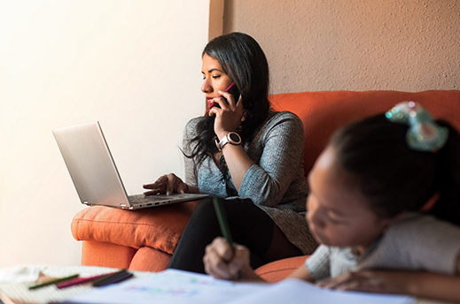 Woman talking on the phone while her daughter colors