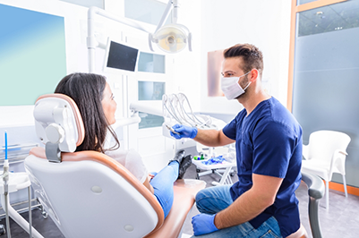 Orthodontist talking to a young woman in the treatment chair