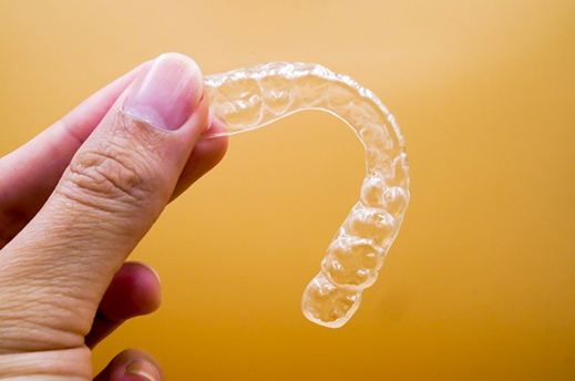 Hand holding a clear retainer