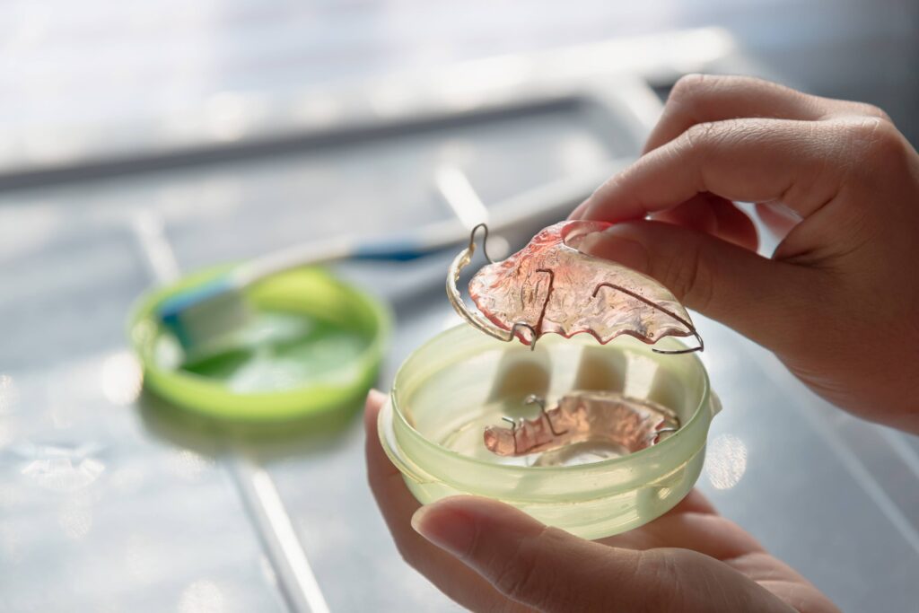 Patient putting retainer in green case