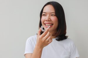 Woman smiling while putting in her Spark clear aligners