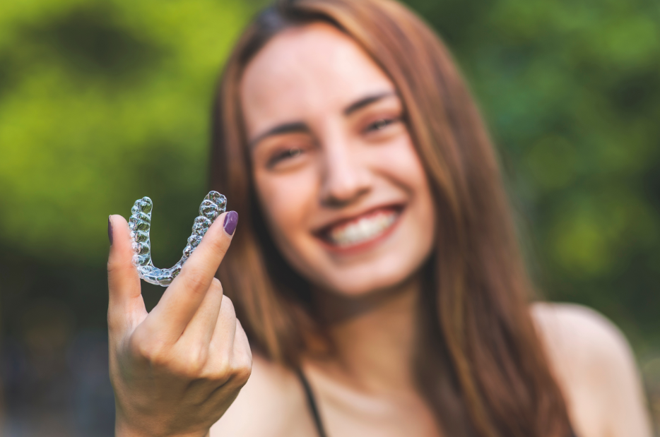 Woman holding clear aligner